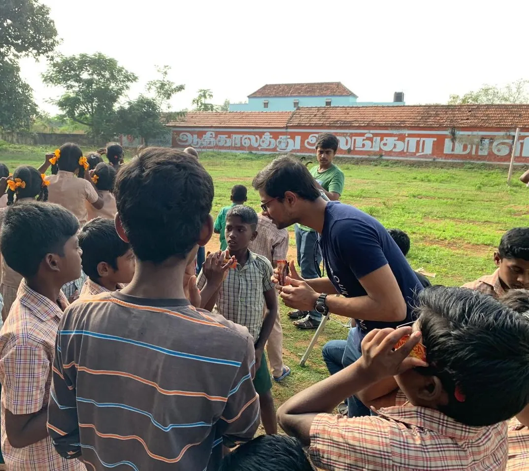 Volunteer helping children observe the sky during a school outreach program