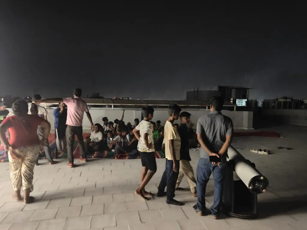 Students taking turns to view Jupiter through a telescope during a night-sky astronomy outreach session in Chennai